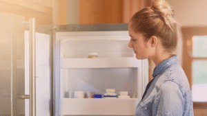 Mulher jovem em frente a uma geladeira aberta